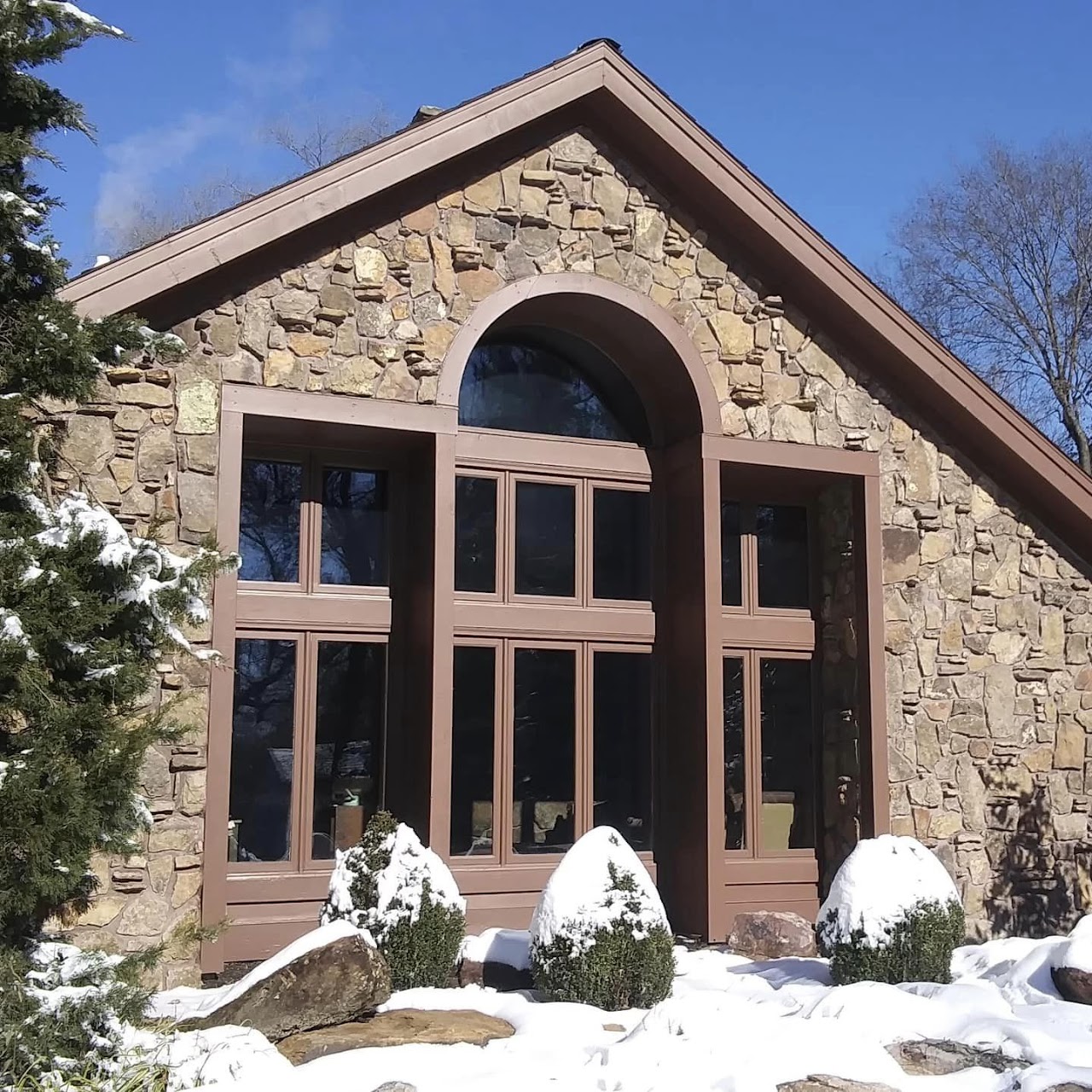 Natural stone facade with an arched window built by Mitts Masonry