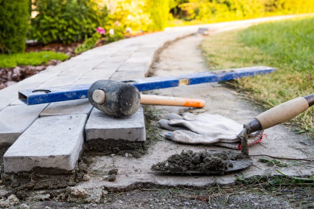 Paving stones being set on a compacted base for a garden path