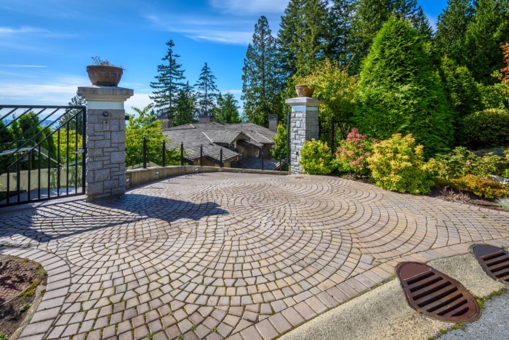 Stone patio and paved drive at a home with a landscaped border